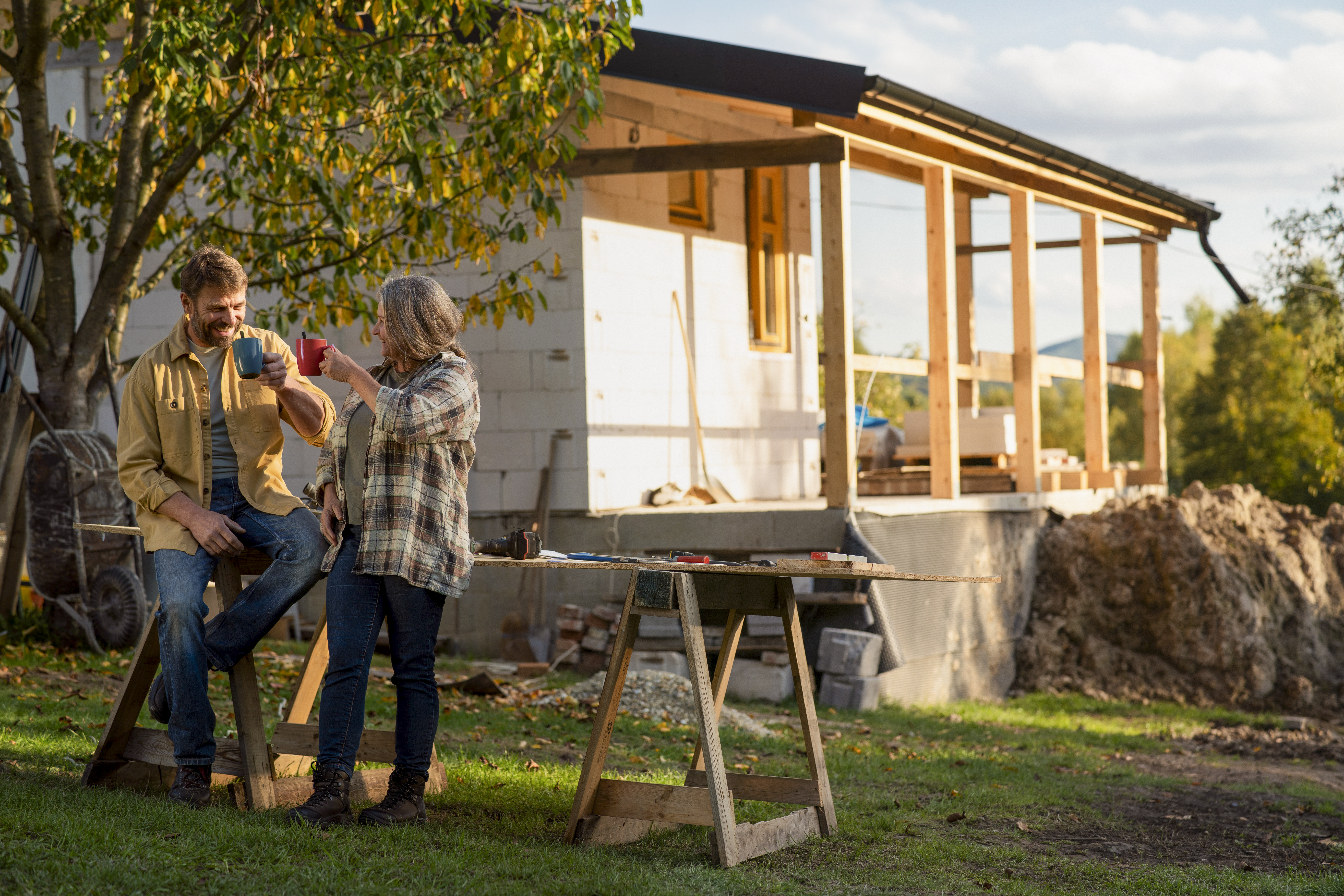 Homeowners at a construction site planning room additions and foundation work for a dream home renovation.